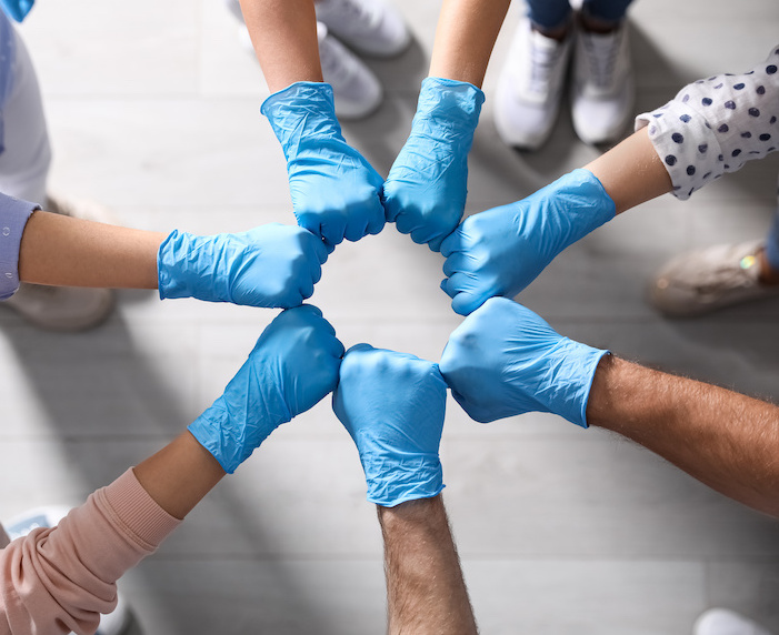 a circle of nurses giving a collective fist-bump